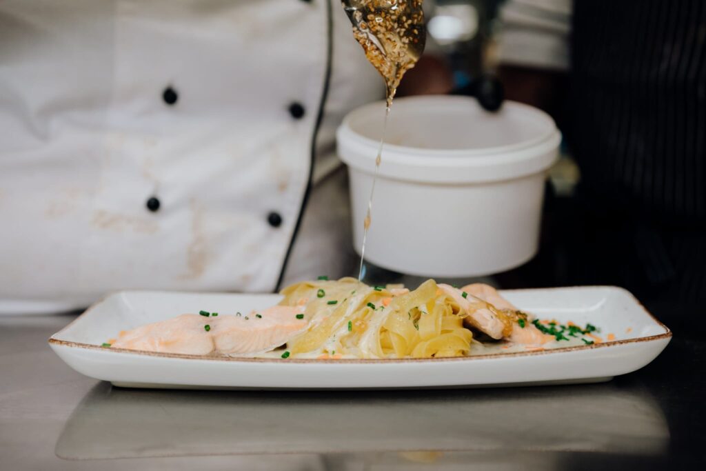 Lachsnudeln werden mit Öl übergossen