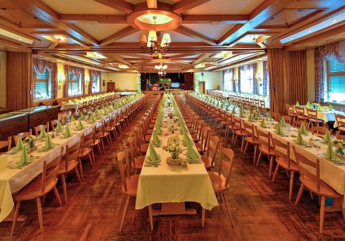 Großer geschmückter Festsaal mit grüner Tischdeko