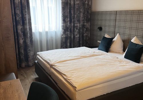 Modernes Doppelzimmer mit dunklen Textilien