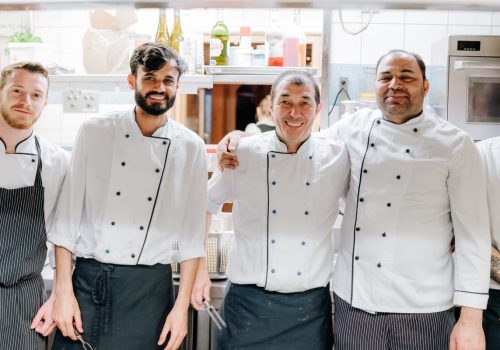 Fünf Köche stehen nebeneinander in die Küche