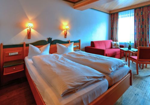 Zimmer mit großem Bett und Sitzmöglichkeiten