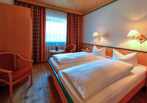 Doppelzimmer mit Bett und Stühlen