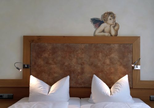 Kopfteil vom Bett mit Engel darüber