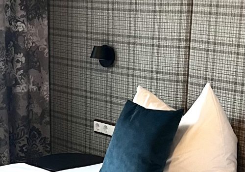 Blaues Dekokissen auf dem Bett