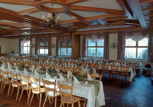 Festlich dekorierter Festsaal mit langen Tischen
